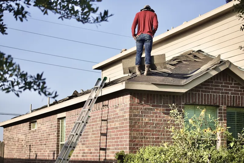 Professional roofer working on a residential roof in Fletcher